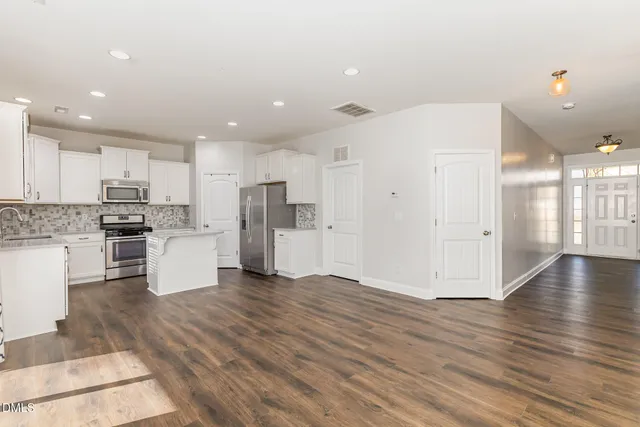 a view of empty room with wooden floor and fireplace