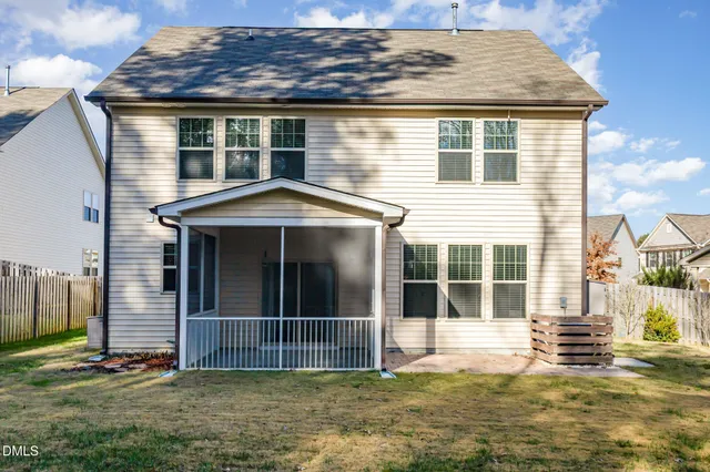 a view of a house with a big yard and large trees
