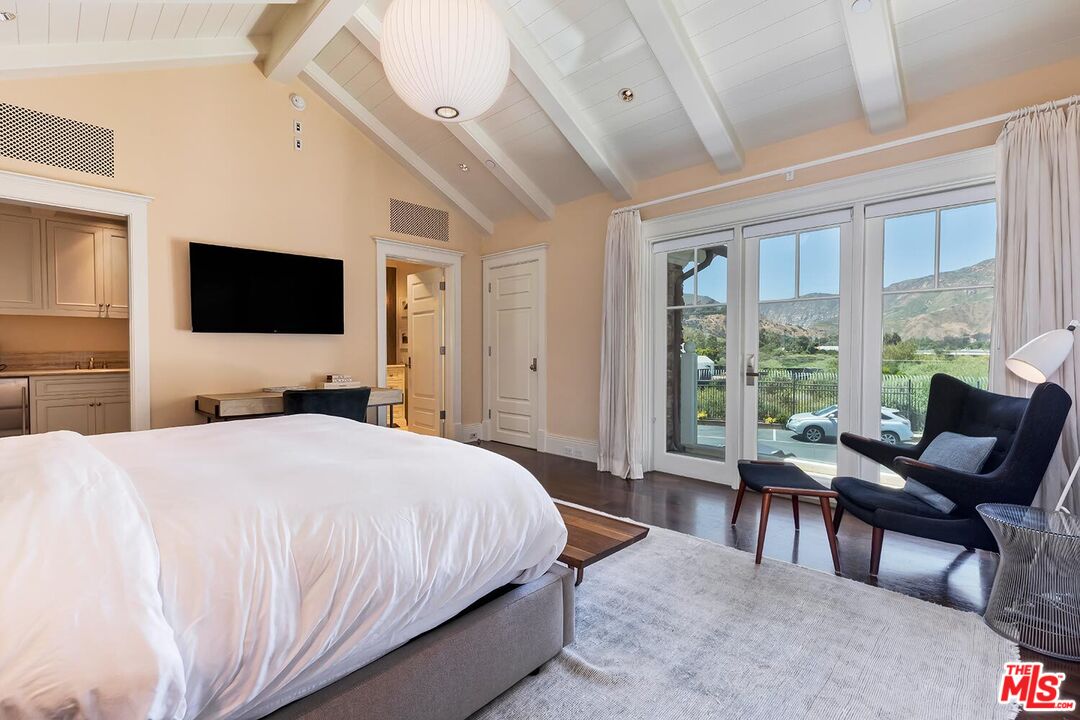 119 Malibu Colony Road Malibu, CA 90265 - Photo 18 of 24 a bedroom with a bed and a flat tv screen next to a large window