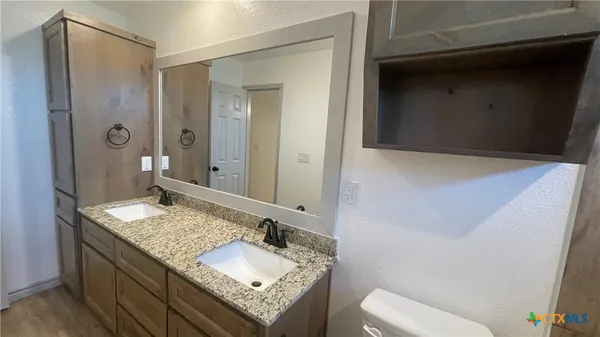 a bathroom with a granite countertop sink and a mirror