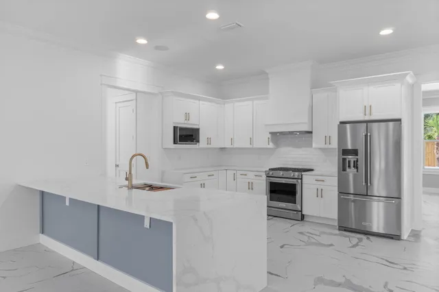 a kitchen with stainless steel appliances granite countertop a sink and white cabinets