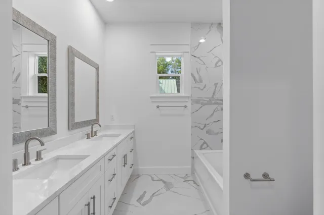 a view of an empty room with wooden floor and a ceiling fan