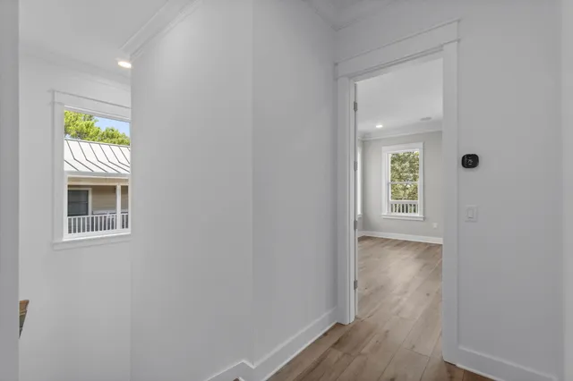 an empty room with wooden floor window and ceiling fan