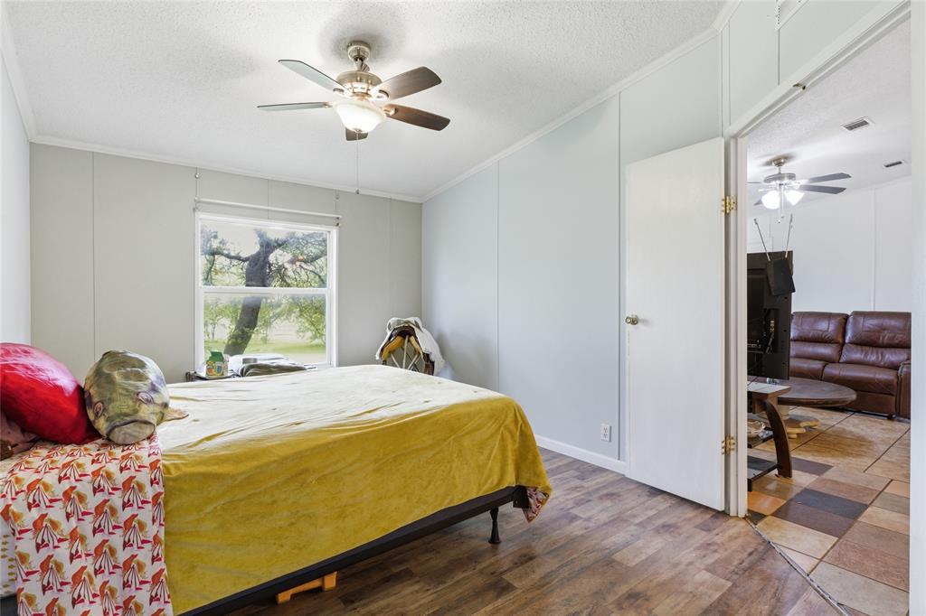 134 Private Road 4523 Decatur, TX 76234 - Photo 23 of 39 a bedroom with a bed and a chandelier