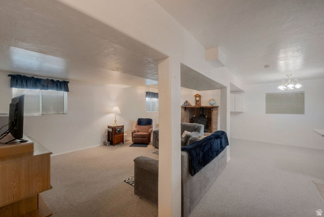 11072 Windy Peak Ridge Drive, Unit 32 Sandy, UT 84094 - Photo 23 of 30 Expansive carpeted living area featuring multiple windows, a corner brick fireplace with a hearth, and overhead lighting