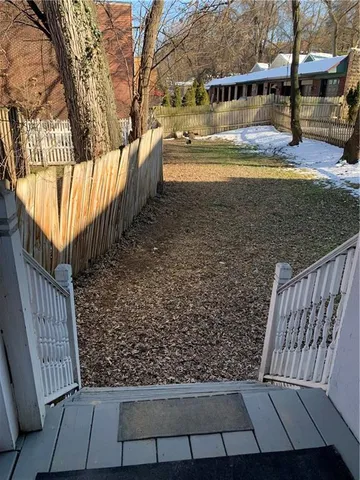 a view of a yard with wooden fence