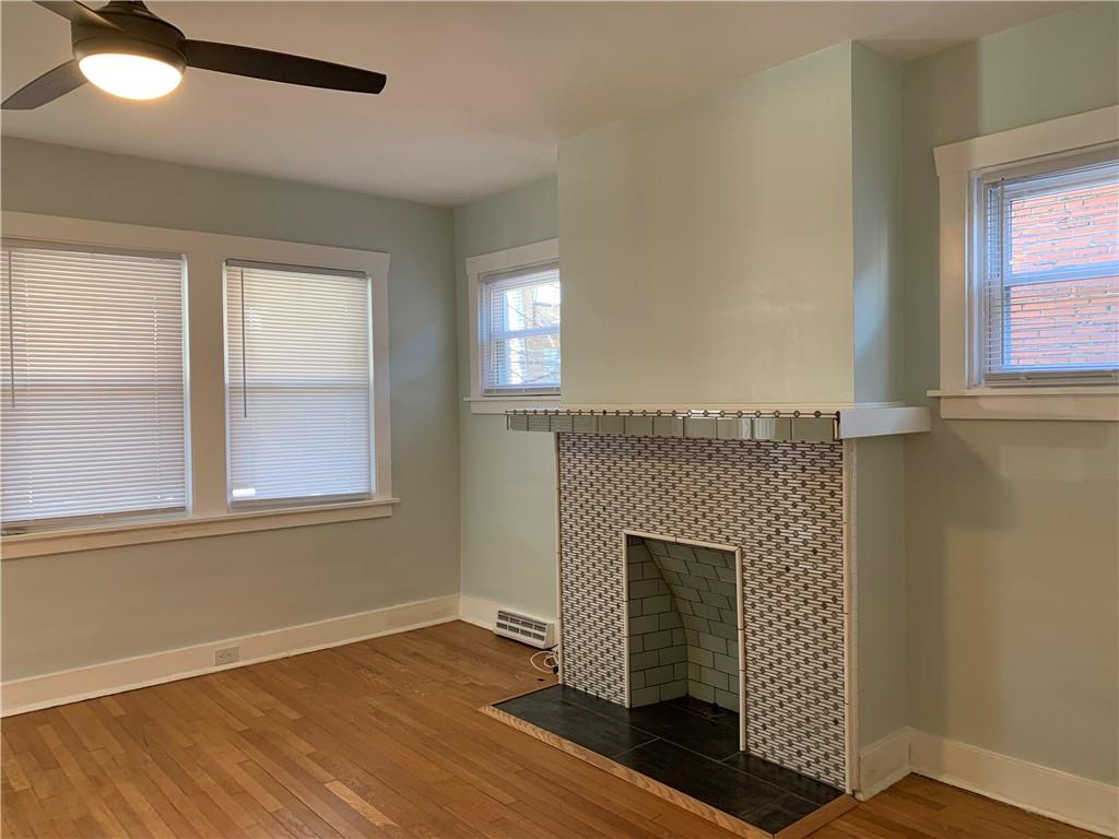 2607 Shady Avenue Pittsburgh, PA 15217 - Photo 3 of 19 an empty room with wooden floor a fireplace and windows