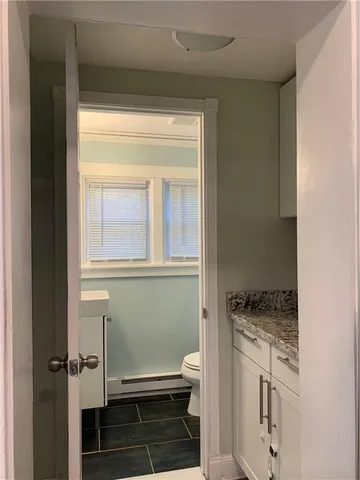 a bathroom with a sink a toilet and a window