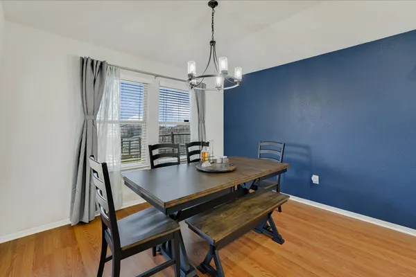 a open kitchen with stainless steel appliances granite countertop a kitchen island a stove a dining table and chairs with wooden floor