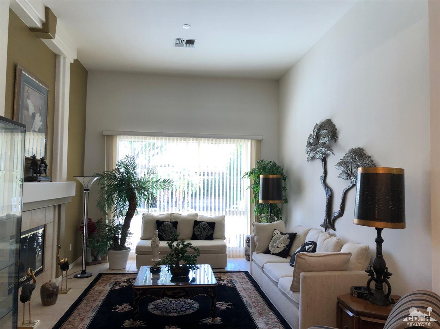 36626 Tallowood Drive Palm Desert, CA 92211 - Photo 3 of 17 a living room with furniture a fireplace and a flat screen tv