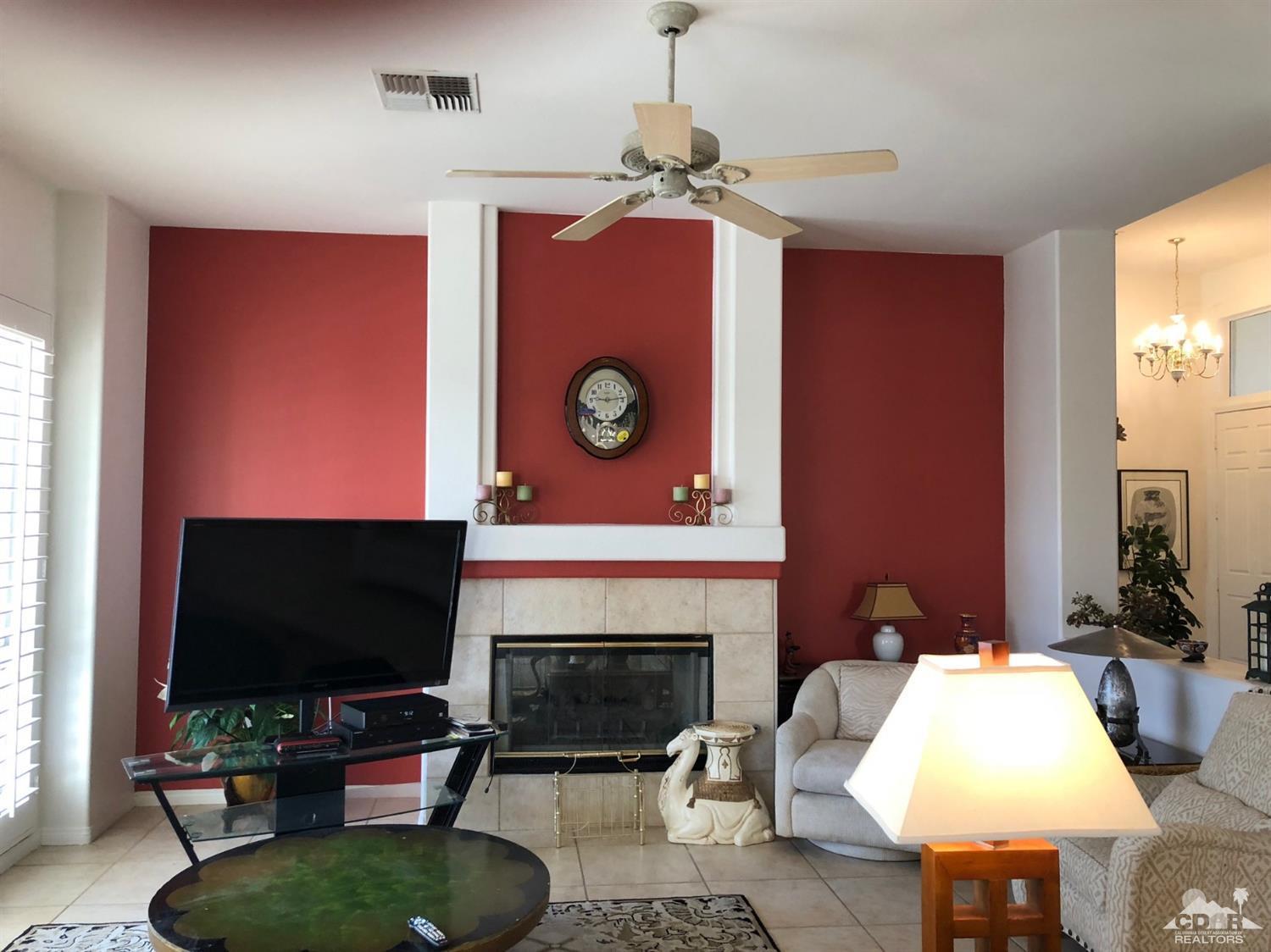 36626 Tallowood Drive Palm Desert, CA 92211 - Photo 6 of 17 a living room with furniture a flat screen tv and a fireplace