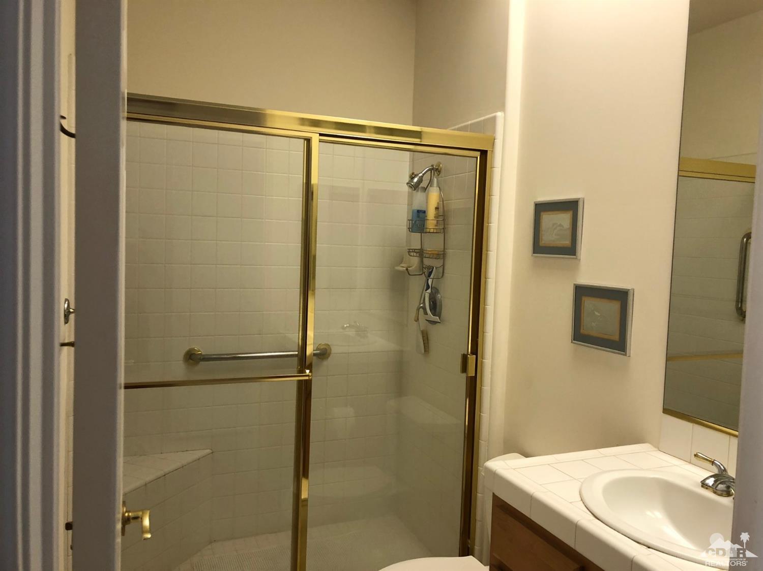 36626 Tallowood Drive Palm Desert, CA 92211 - Photo 10 of 17 a bathroom with a granite countertop shower sink vanity and a toilet