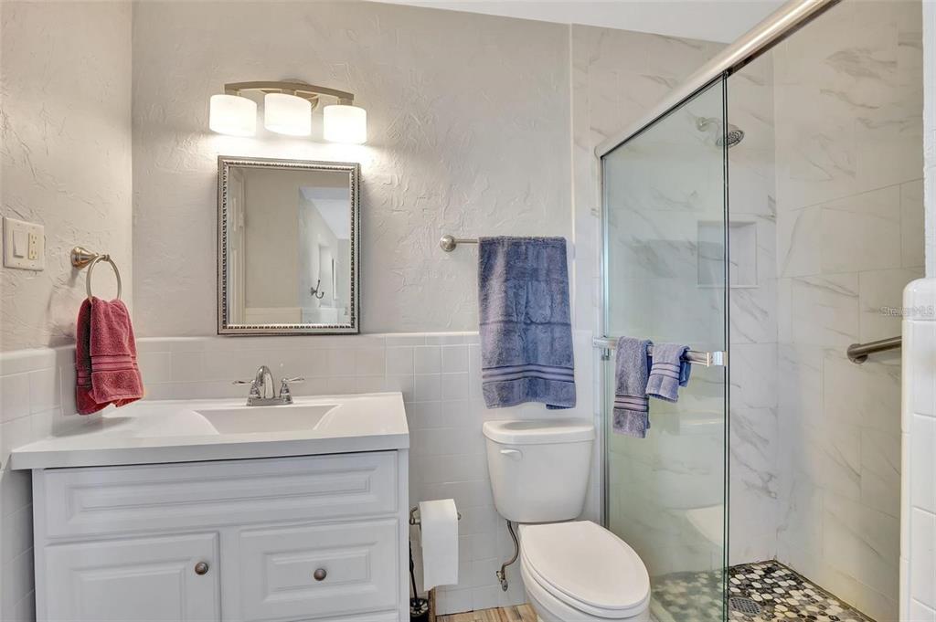 250 Bangsberg Road Southeast Port Charlotte, FL 33952 - Photo 19 of 59 a bathroom with a sink toilet vanity and shower