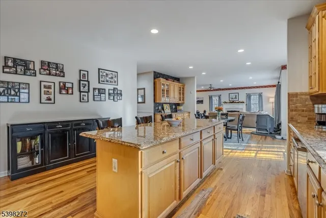 a large kitchen with stainless steel appliances granite countertop a lot of counter space and a wooden floors