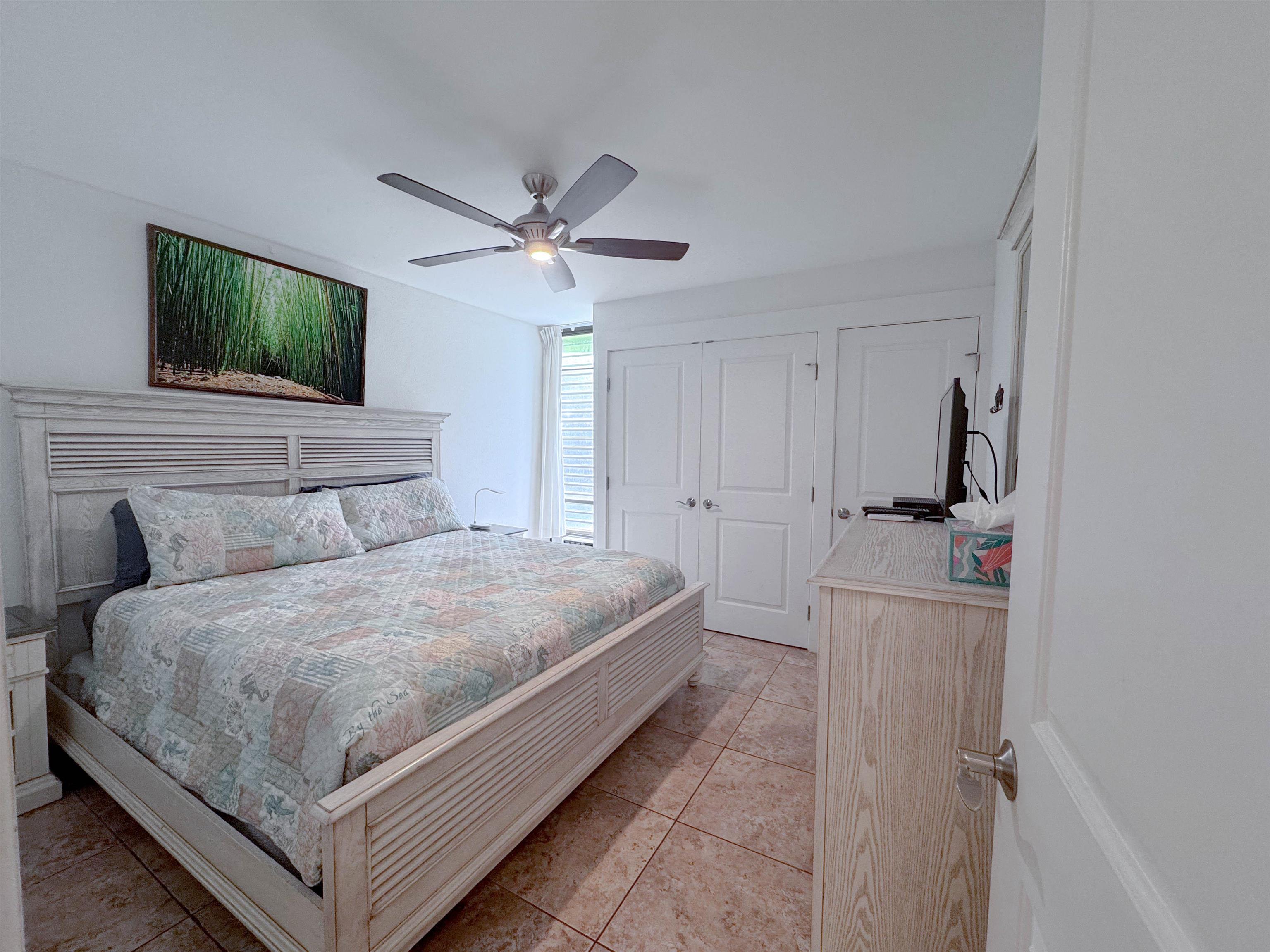 483 South Kihei Road, Unit 115 Kihei, HI 96753 - Photo 13 of 36 a bedroom with a bed and a flat screen tv
