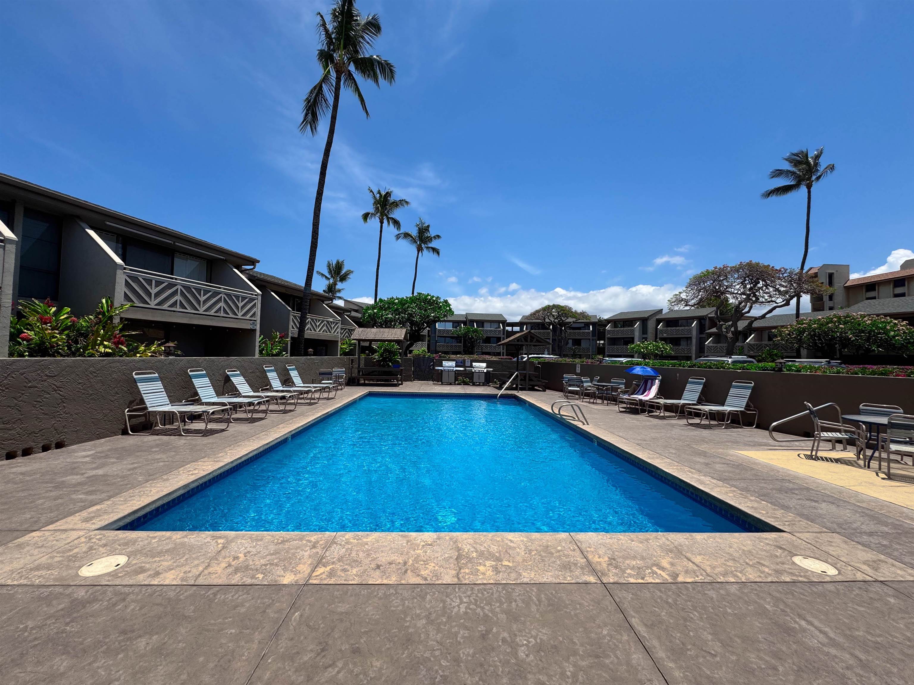 483 South Kihei Road, Unit 115 Kihei, HI 96753 - Photo 23 of 36 a view of a swimming pool with a table and chairs