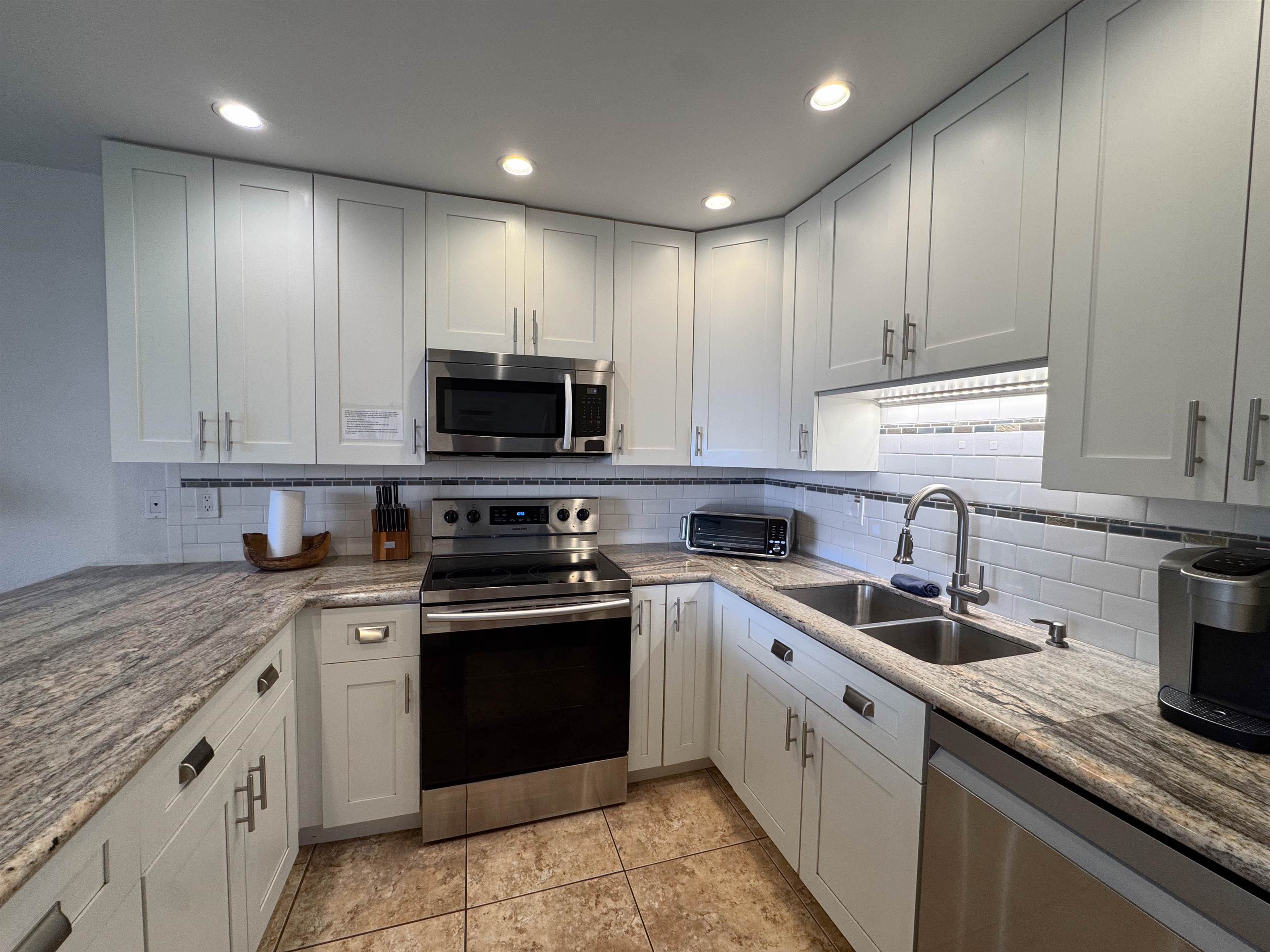 483 South Kihei Road, Unit 115 Kihei, HI 96753 - Photo 5 of 36 a kitchen with appliances cabinets and a sink