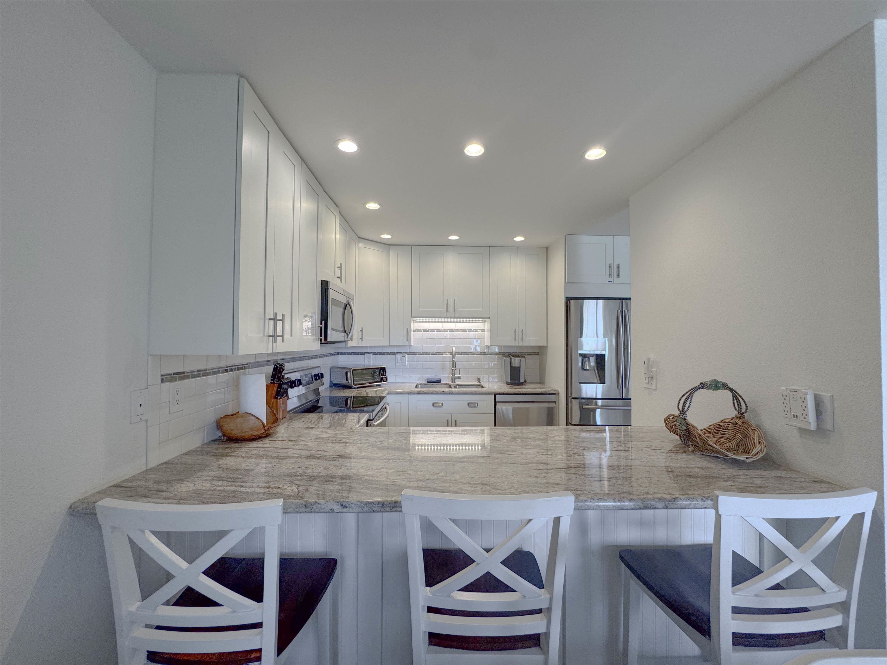 483 South Kihei Road, Unit 115 Kihei, HI 96753 - Photo 6 of 36 a kitchen with sink a refrigerator and cabinets