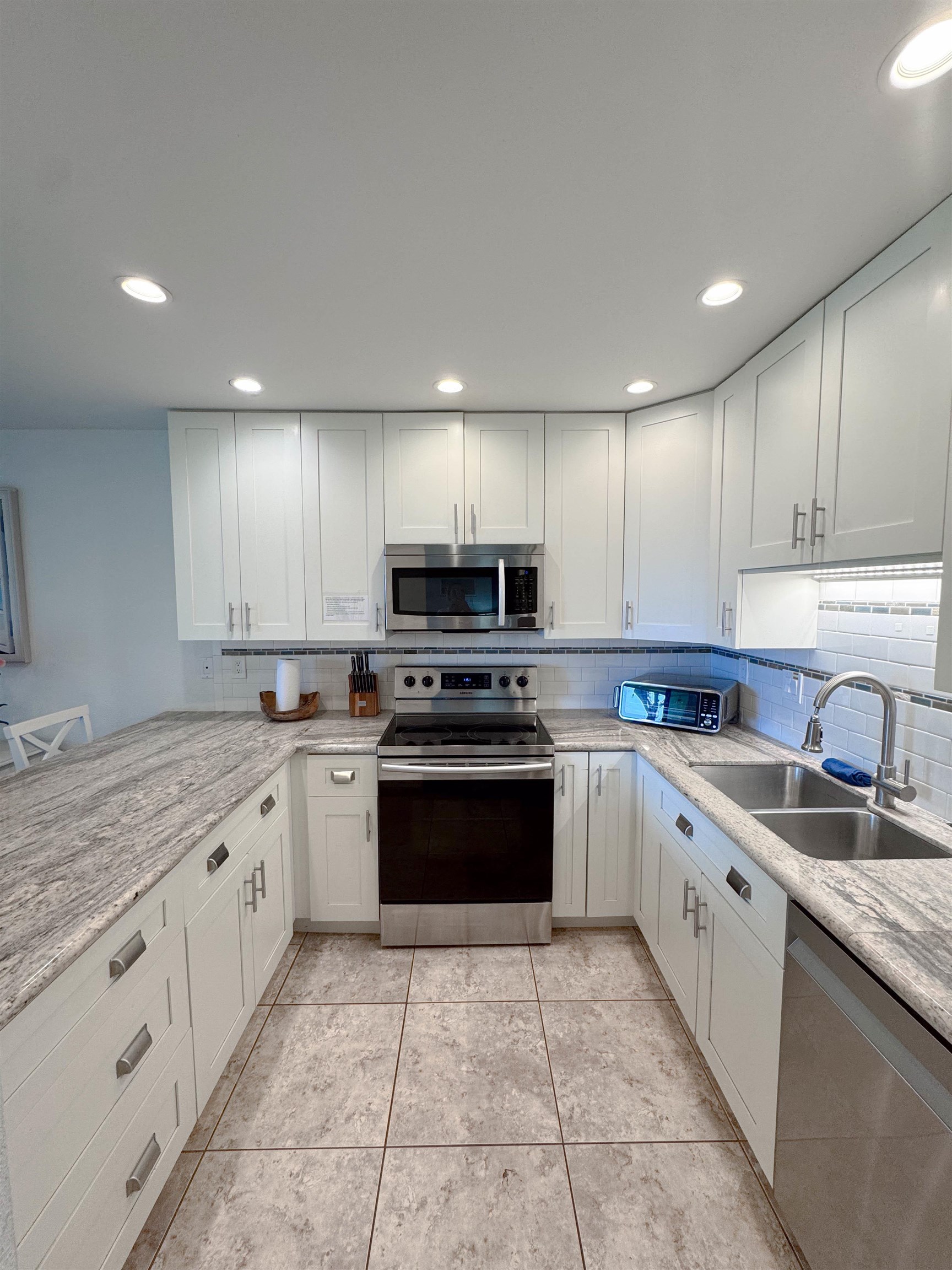483 South Kihei Road, Unit 115 Kihei, HI 96753 - Photo 8 of 36 a kitchen with granite countertop a sink and white cabinets