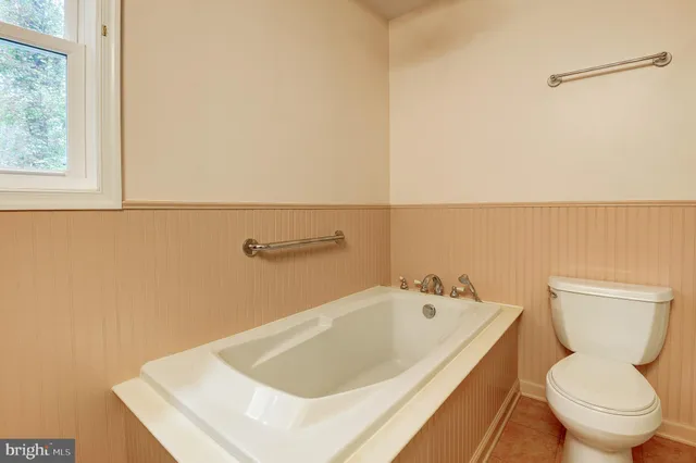 a white bath tub sitting next to a toilet