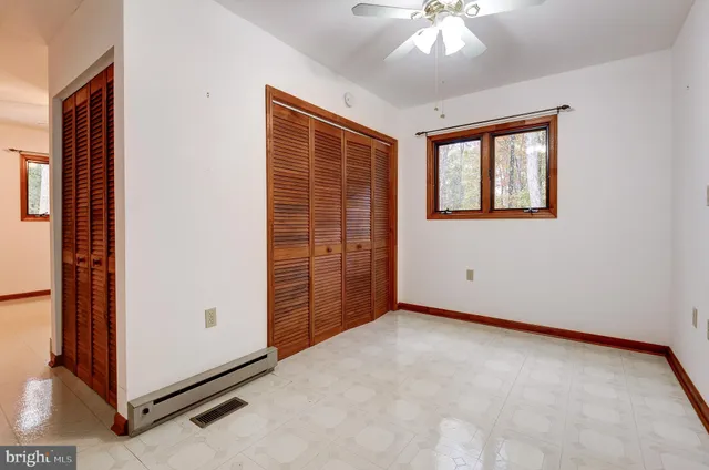 an empty room with windows and closet