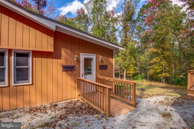 a view of a house with a small yard and wooden floor and fence