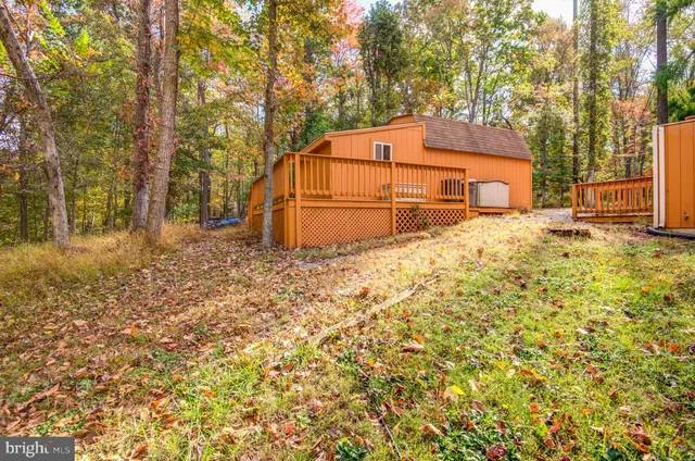a backyard of a house with large trees and covered by wooden fence