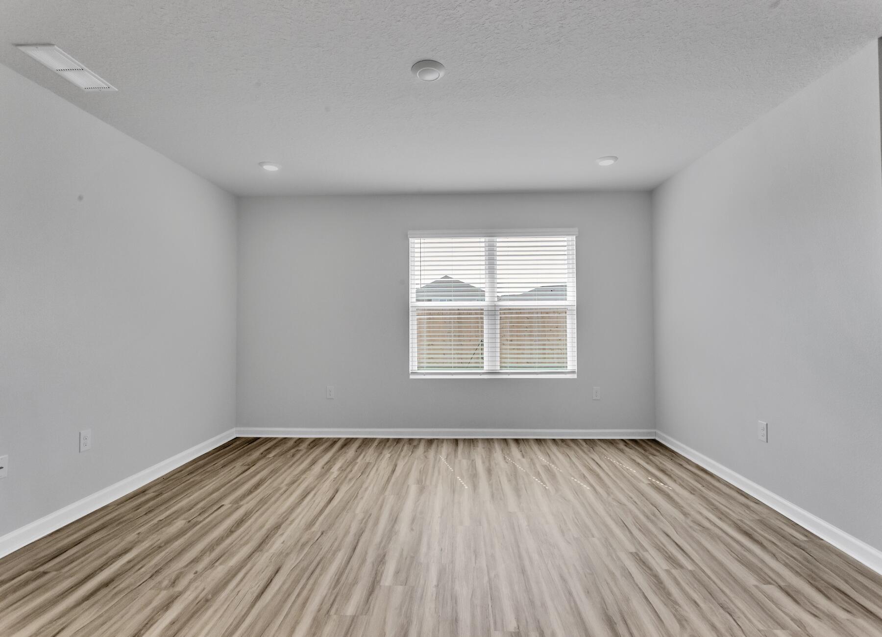 839 Otto Loop Crestview, FL 32539 - Photo 22 of 34 an empty room with wooden floor and windows