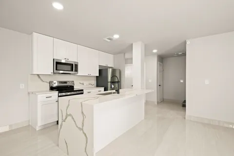 a kitchen with microwave a stove and refrigerator