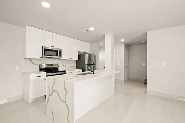 a kitchen with microwave a stove and refrigerator