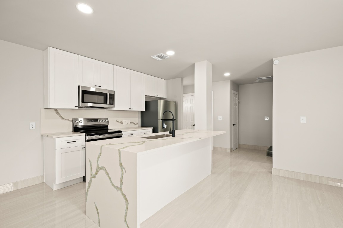 a kitchen with microwave a stove and refrigerator