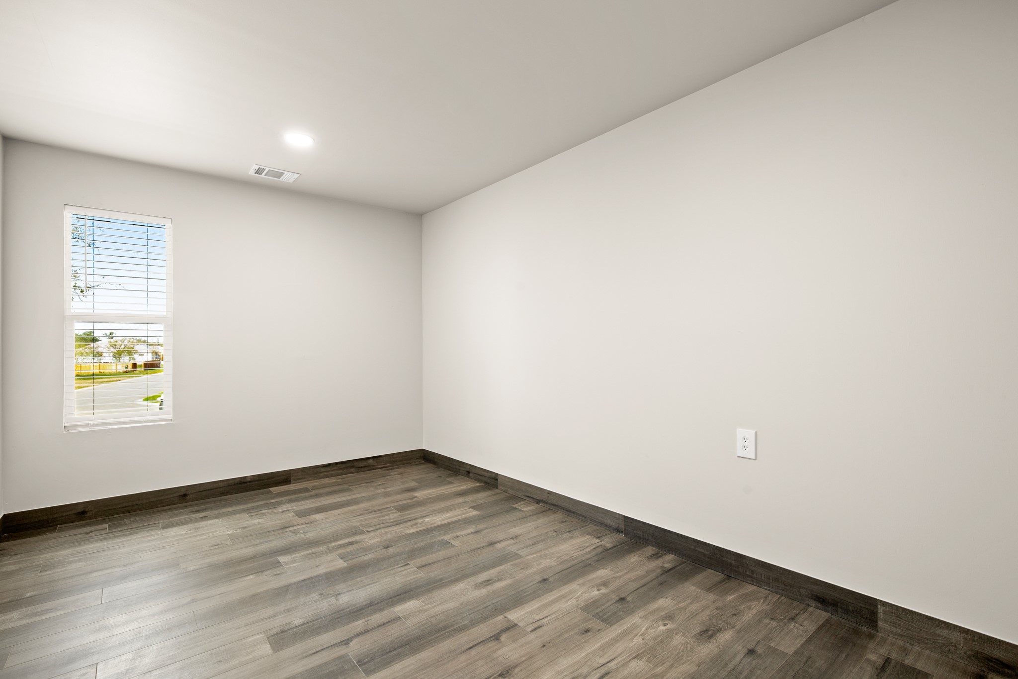 183 Mimosa Road Dale, TX 78616 - Photo 9 of 32 an empty room with wooden floor and windows