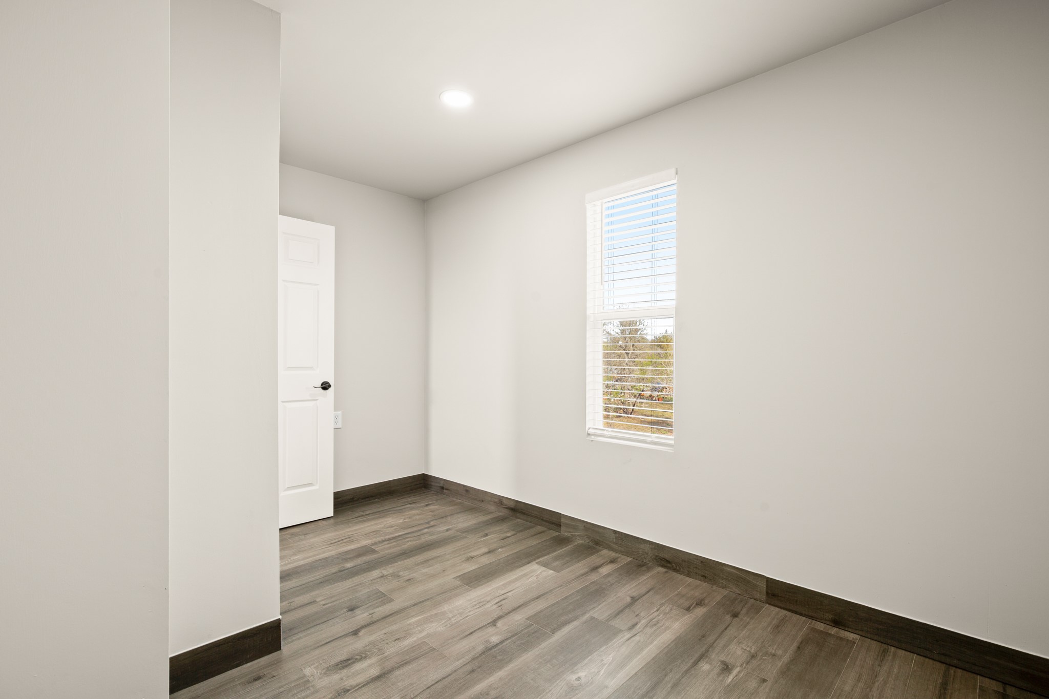 183 Mimosa Road Dale, TX 78616 - Photo 10 of 32 a view of an empty room with wooden floor and a window