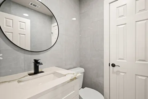 a bathroom with a granite countertop sink toilet and shower