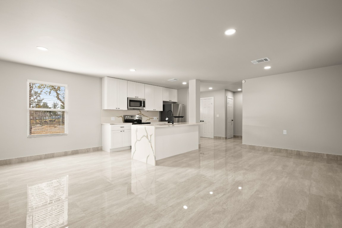 183 Mimosa Road Dale, TX 78616 - Photo 31 of 32 a view of kitchen with stainless steel appliances refrigerator oven and white cabinets with wooden floor