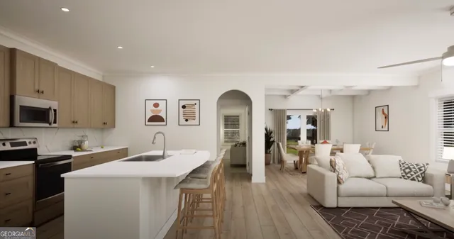 a living room with furniture kitchen view and a wooden floor