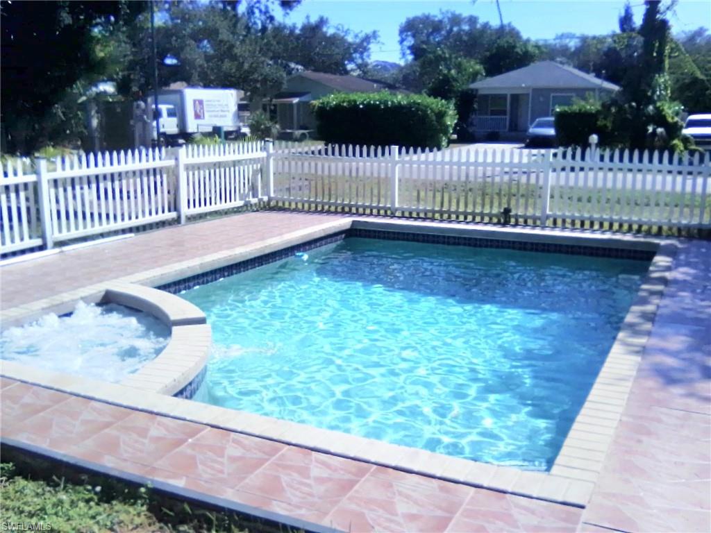 a view of a house with wooden fence and a bench