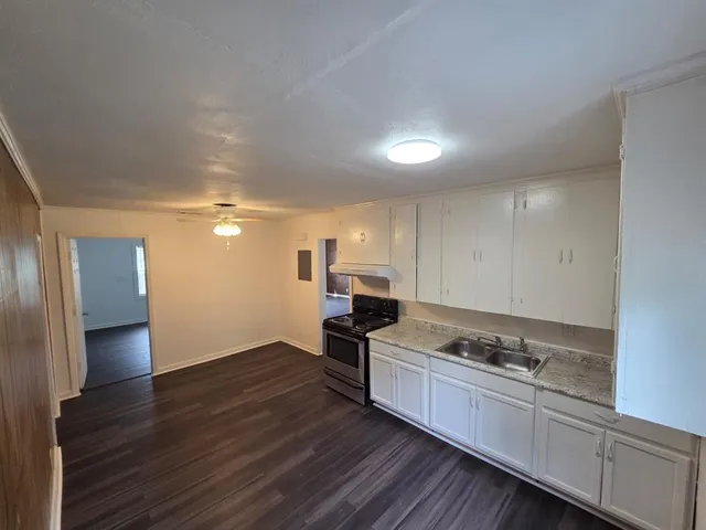 a kitchen with granite countertop a stove and cabinets