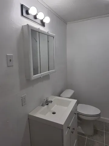 a bathroom with a toilet a sink and mirror