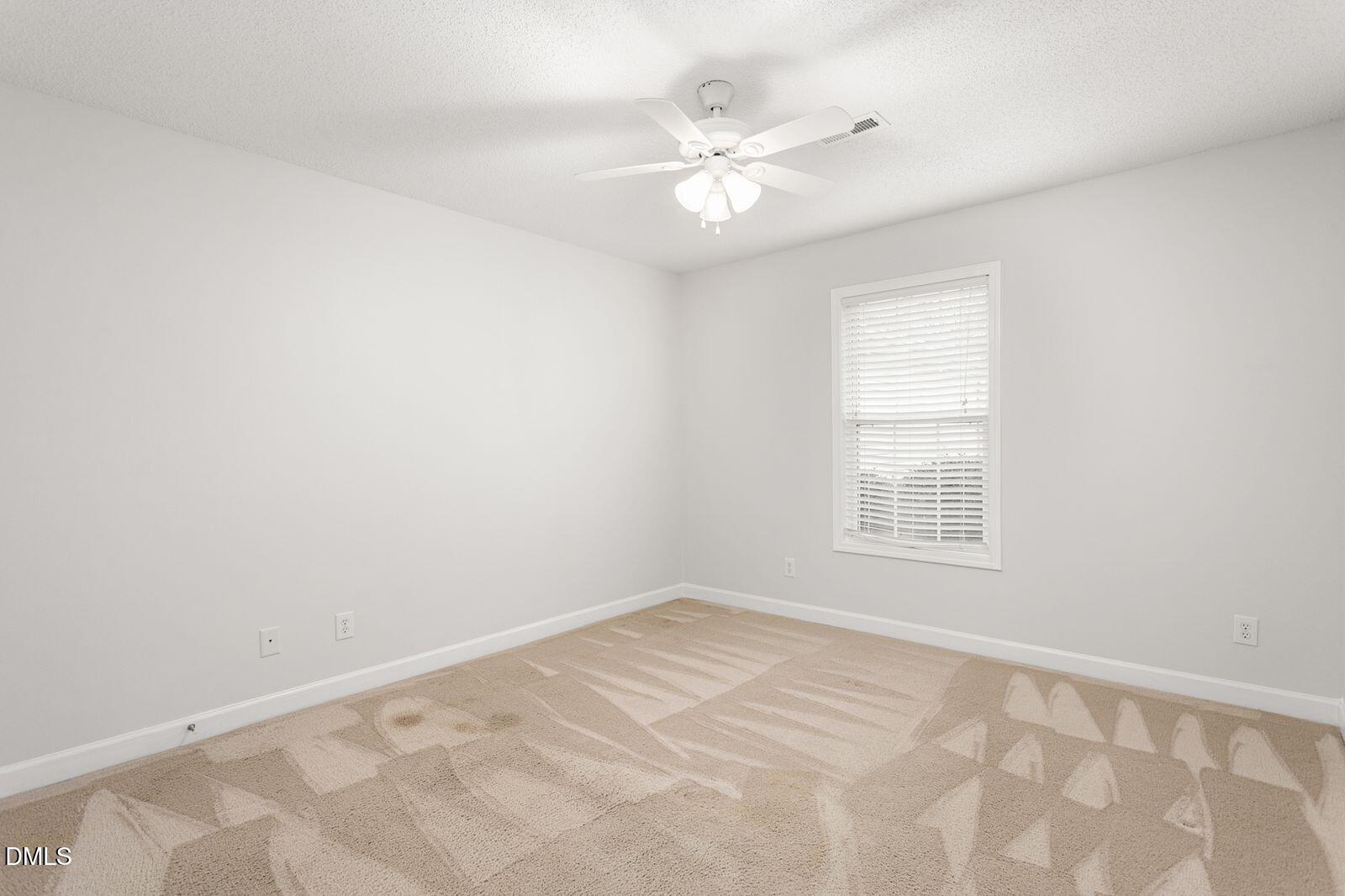 605 Huntingdon Street Elon, NC 27244 - Photo 15 of 18 an empty room with chandelier fan and windows