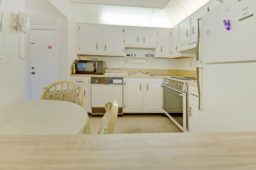9440 Southwest 8th Street, Unit 220 Boca Raton, FL 33428 - Photo 2 of 9 a kitchen with stainless steel appliances granite countertop a refrigerator sink and white cabinets