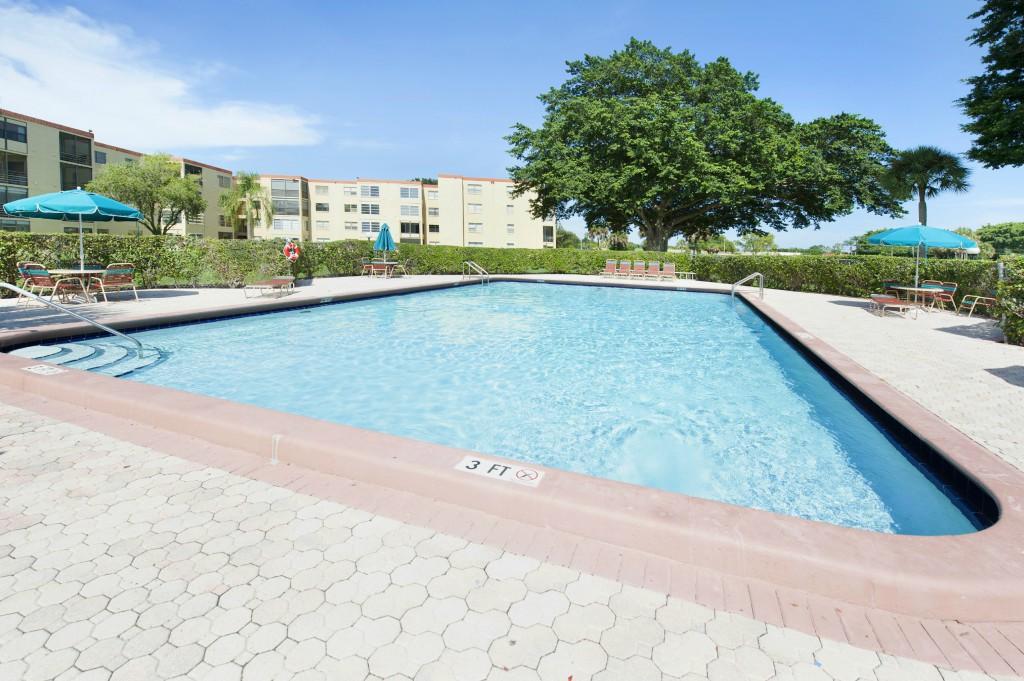 9440 Southwest 8th Street, Unit 220 Boca Raton, FL 33428 - Photo 9 of 9 a view of a swimming pool and a yard