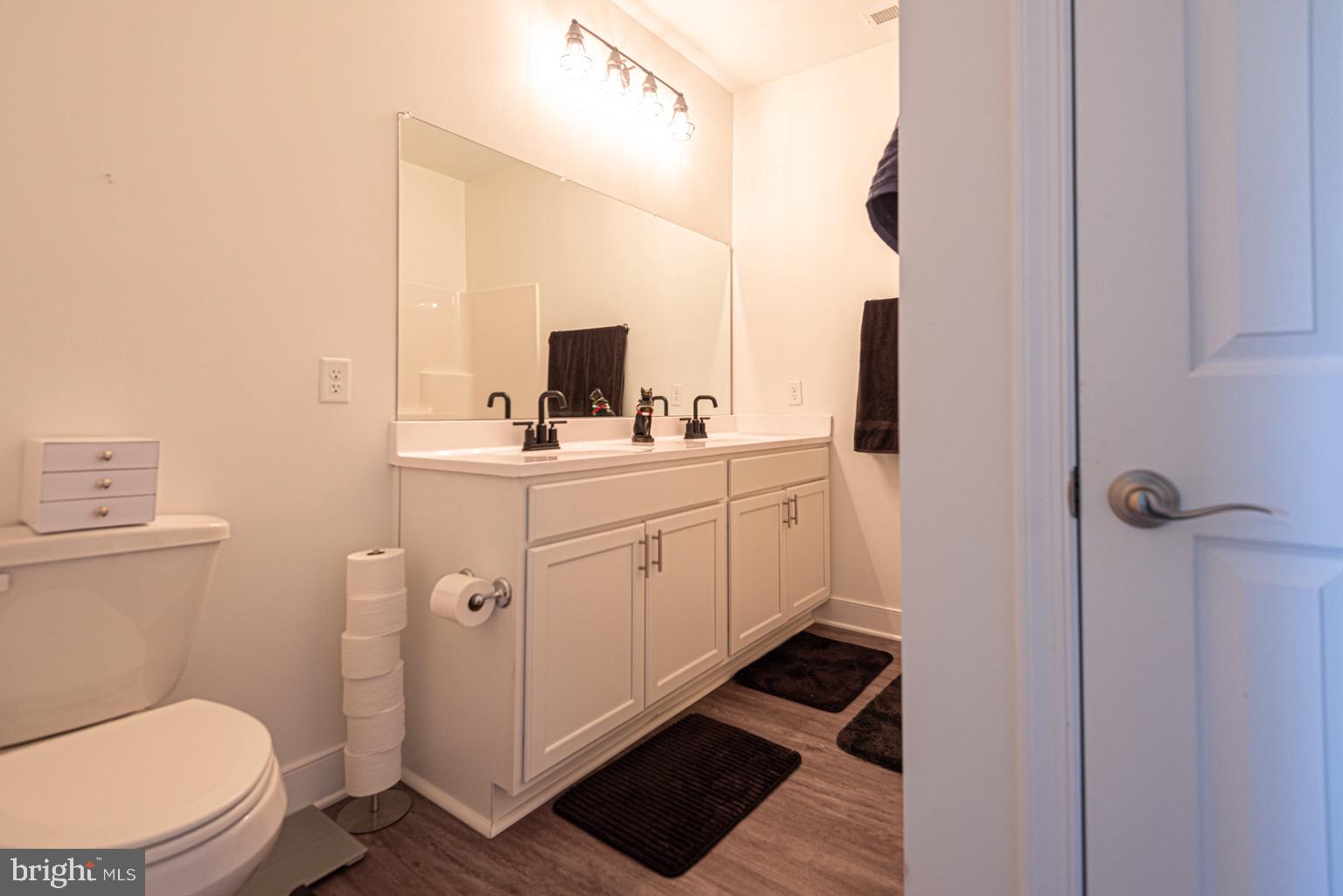 30609 Cedar Neck Road, Unit 3103 Ocean View, DE 19970 - Photo 23 of 39 a bathroom with a toilet sink and mirror