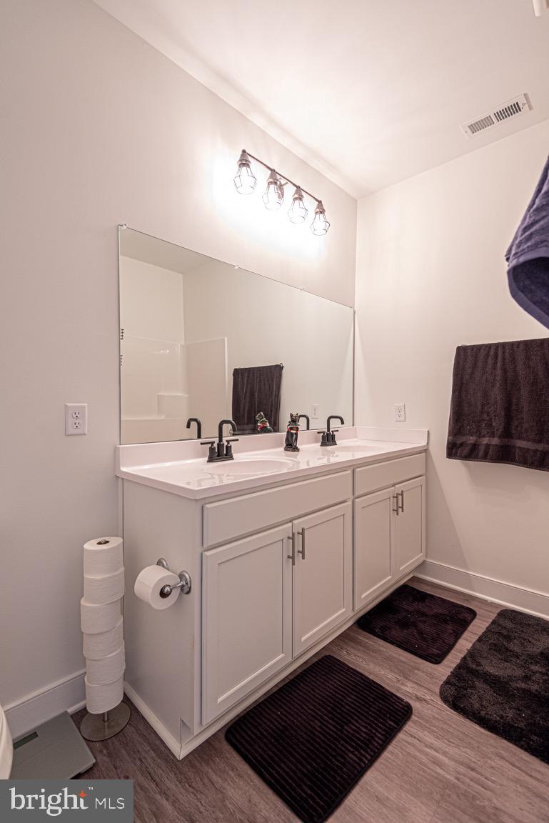 30609 Cedar Neck Road, Unit 3103 Ocean View, DE 19970 - Photo 24 of 39 a spacious bathroom with a double vanity sink a mirror and a toilet