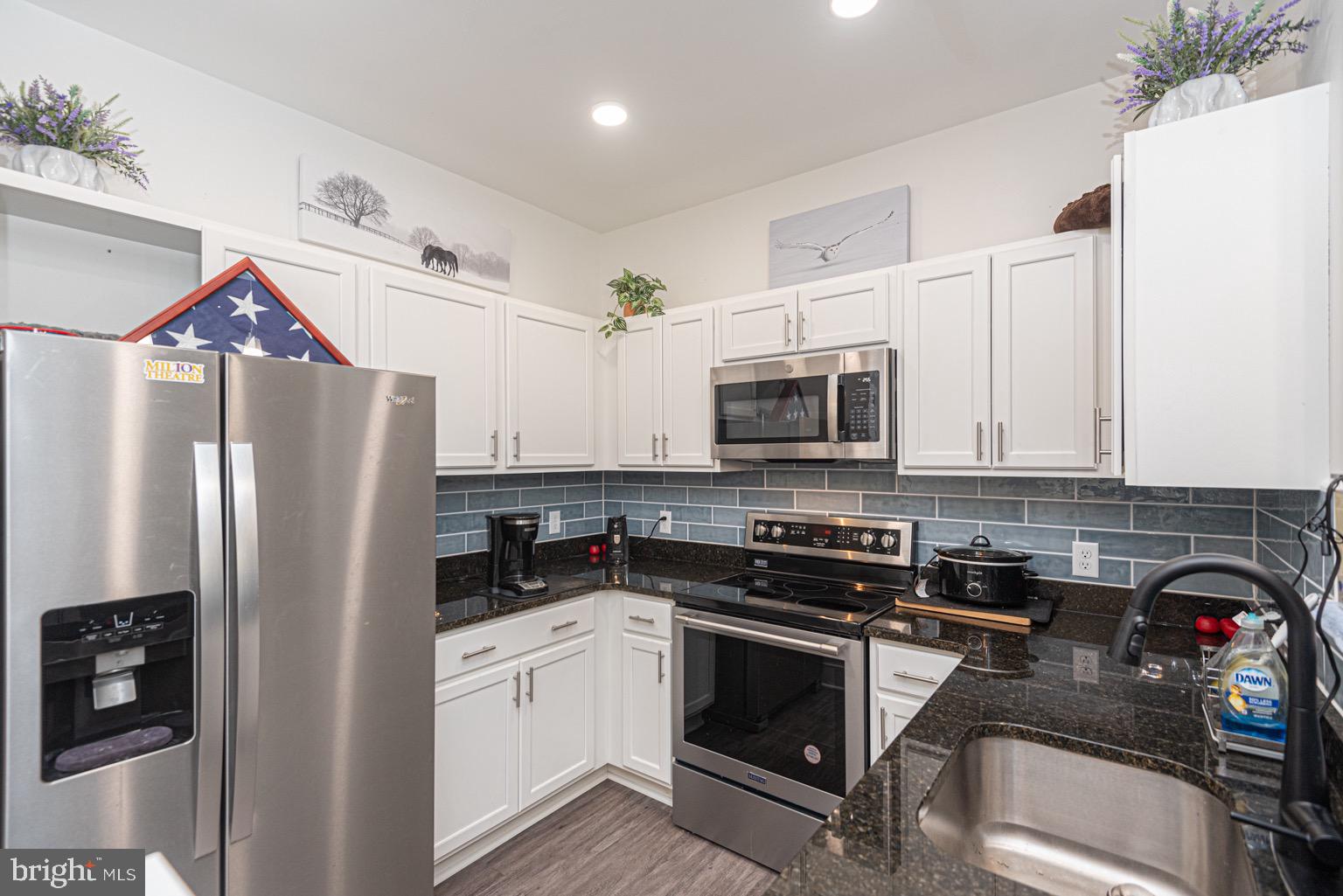 30609 Cedar Neck Road, Unit 3103 Ocean View, DE 19970 - Photo 7 of 39 a kitchen with stainless steel appliances granite countertop a refrigerator stove and sink