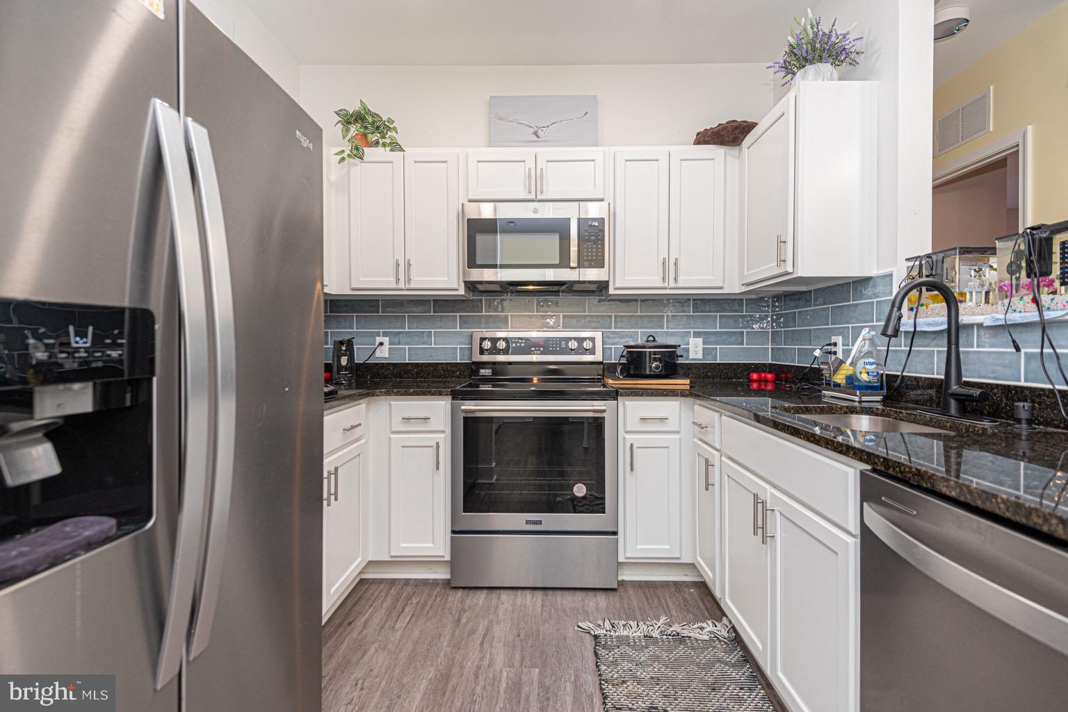 30609 Cedar Neck Road, Unit 3103 Ocean View, DE 19970 - Photo 8 of 39 a kitchen with a white stove top oven and refrigerator