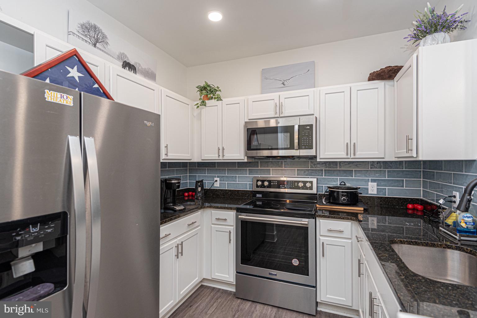 30609 Cedar Neck Road, Unit 3103 Ocean View, DE 19970 - Photo 9 of 39 a kitchen with stainless steel appliances granite countertop a refrigerator stove microwave and sink