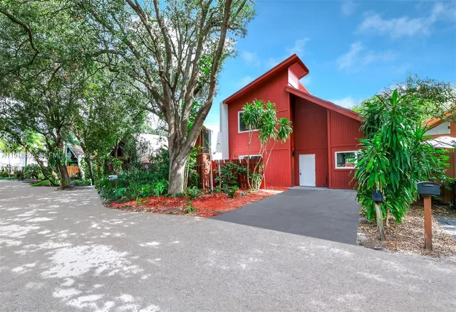 a front view of a house with a yard and potted plants