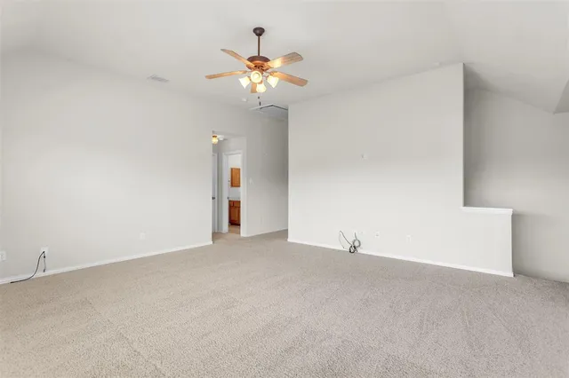 a view of an empty room with a chandelier fan