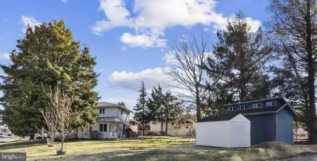 a front view of a house with a garden and trees